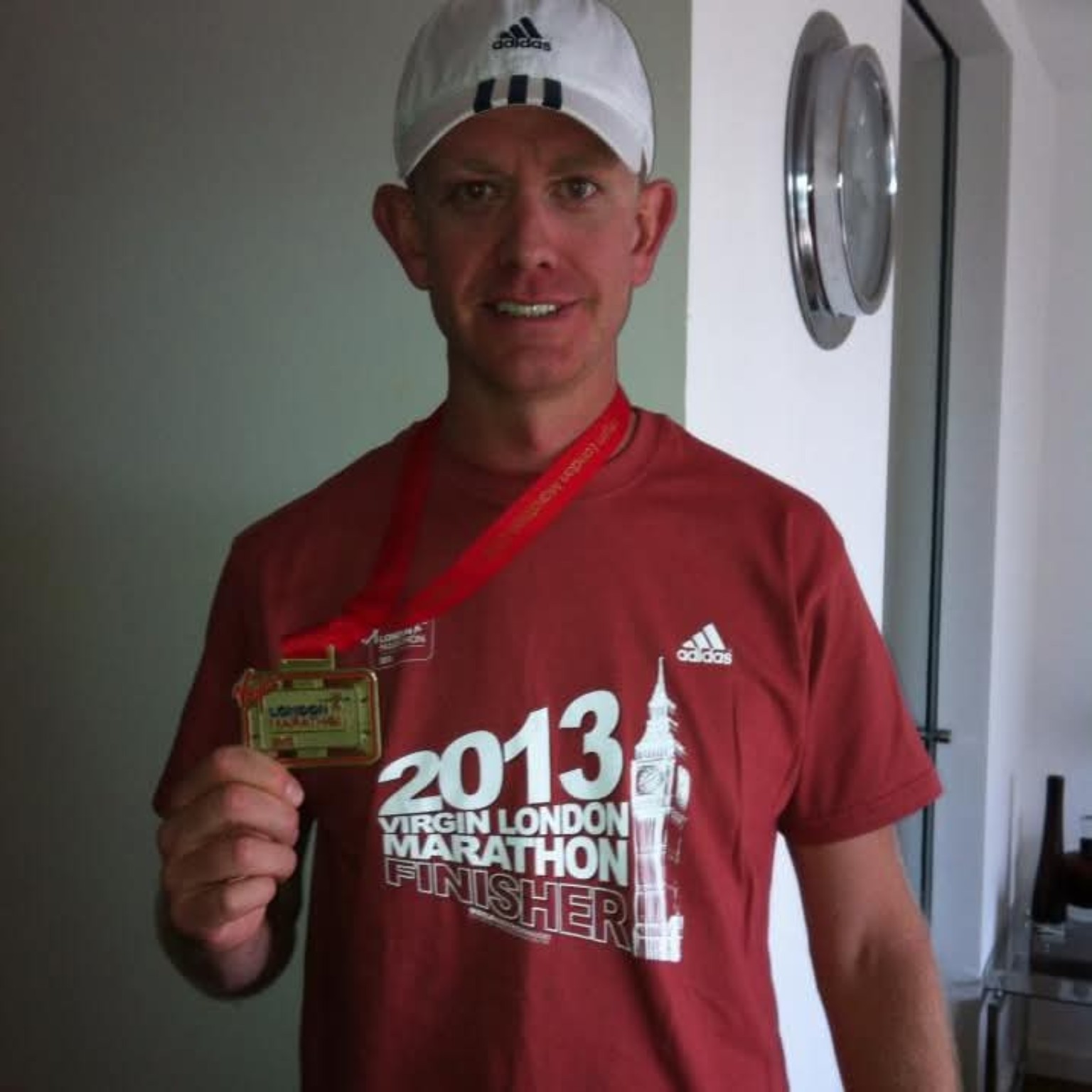 Greg Kench holding a race medal